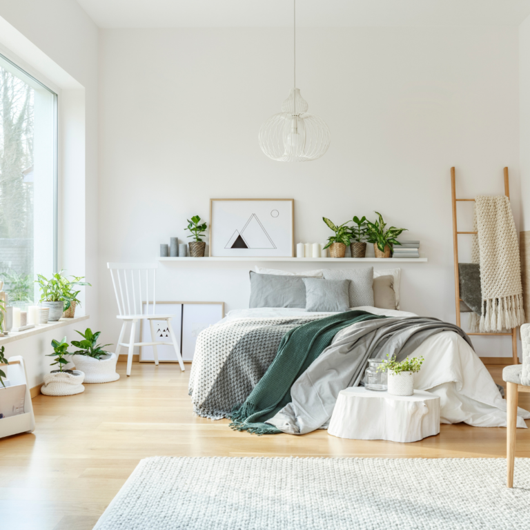 A bedroom with a bed and plants.