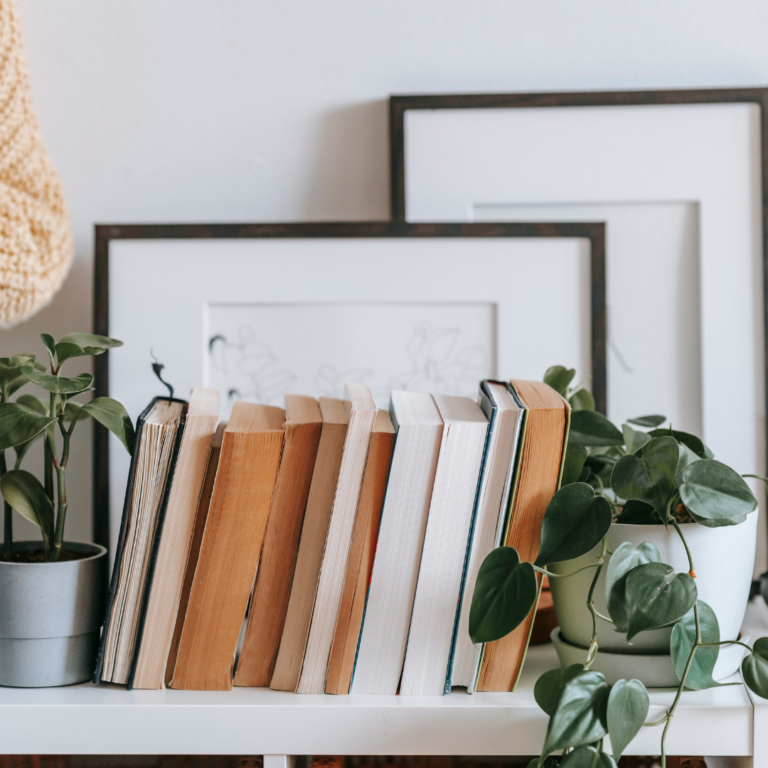 Ways to Display Houseplants: A group of books on a shelf with potted plants.